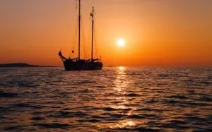 Ankeren in de zonsondergang met een traditioneel zeilschip
