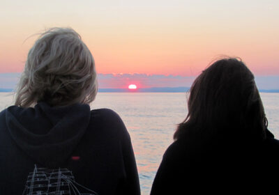 Mensen bekijken de zonsondergang op zee