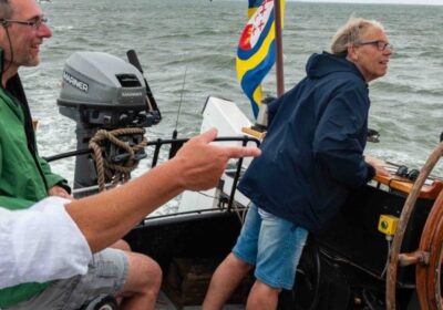 Een groep mensen op het achterdek van een zeilschip
