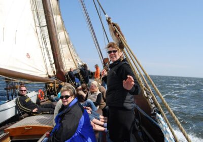 Mensen genieten aan dek van een zeilschip