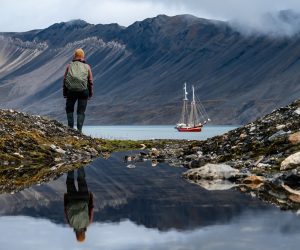 Noorderlicht anchored with guest hiking Svalbard Summer