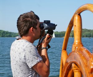 Een man met verrekijker tijdens een zeilvakantie