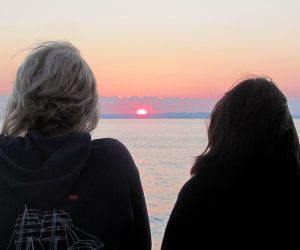 Mensen bekijken de zonsondergang op zee